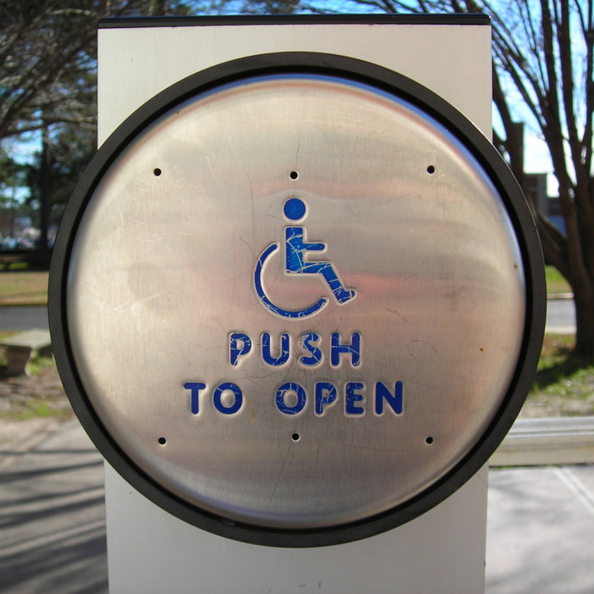 Photo of a door opener button with the words "Push to open"